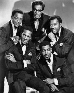 Die fünf Bandmitgliedervon The Tempations posieren hockend und stehend, eng beieinander. Das Foto entstand 1964.